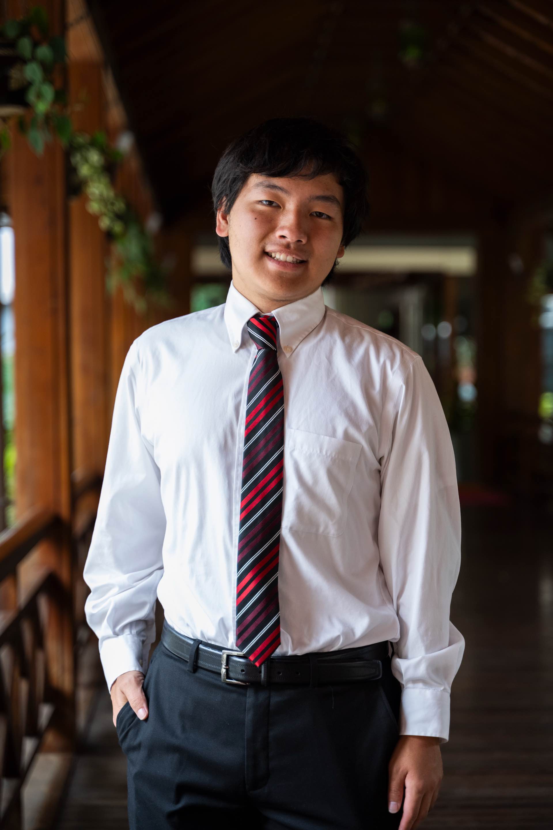 Portrait of Gavin Huang in a white shirt and striped tie