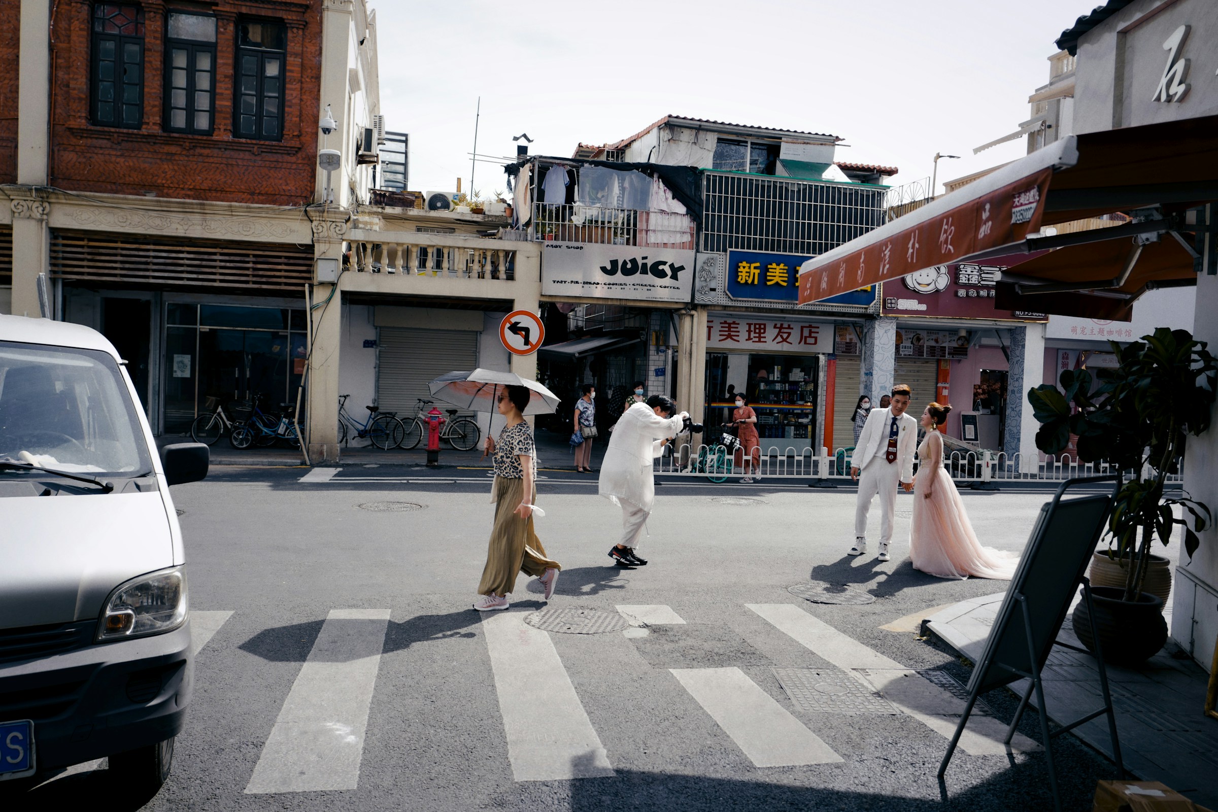 People walking across a city street alongside vehicles
